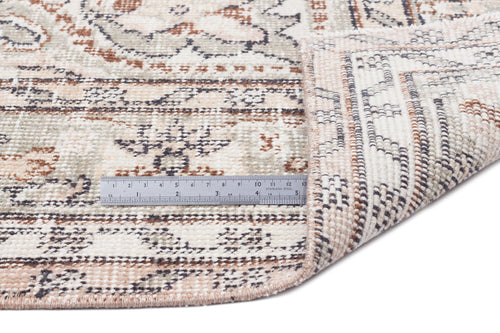 Load image 1 in gallery view. Cream, sage, and rust-toned rug with a distressed traditional pattern, shown with a metal ruler for scale.