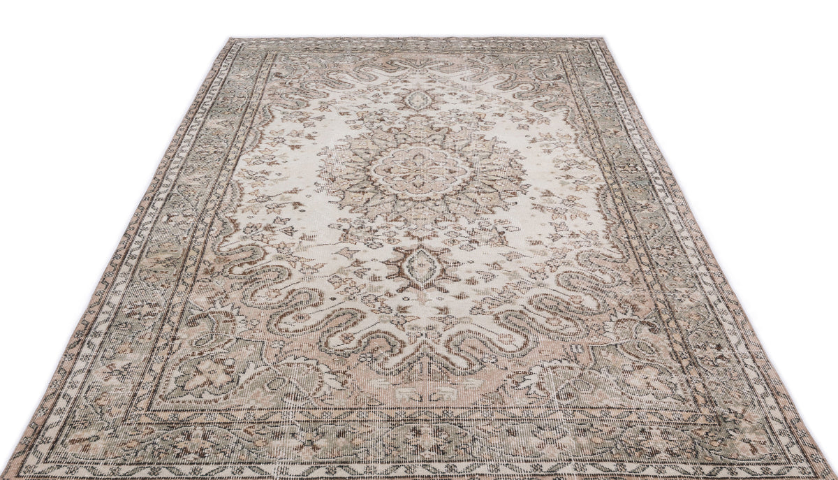 Distressed beige and sage green area rug with a traditional central medallion and ornate floral border.