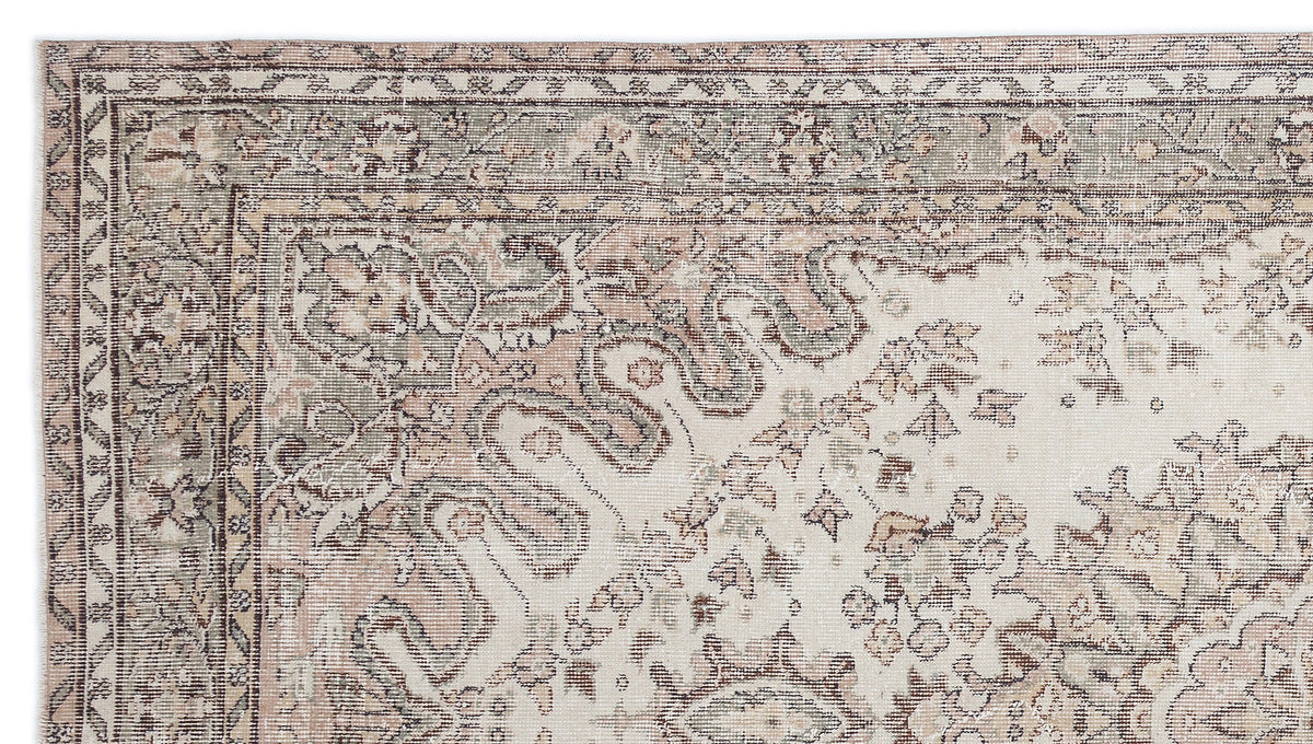 Distressed vintage-style rug with a cream field, sage green and terracotta floral motifs, and a geometric border.