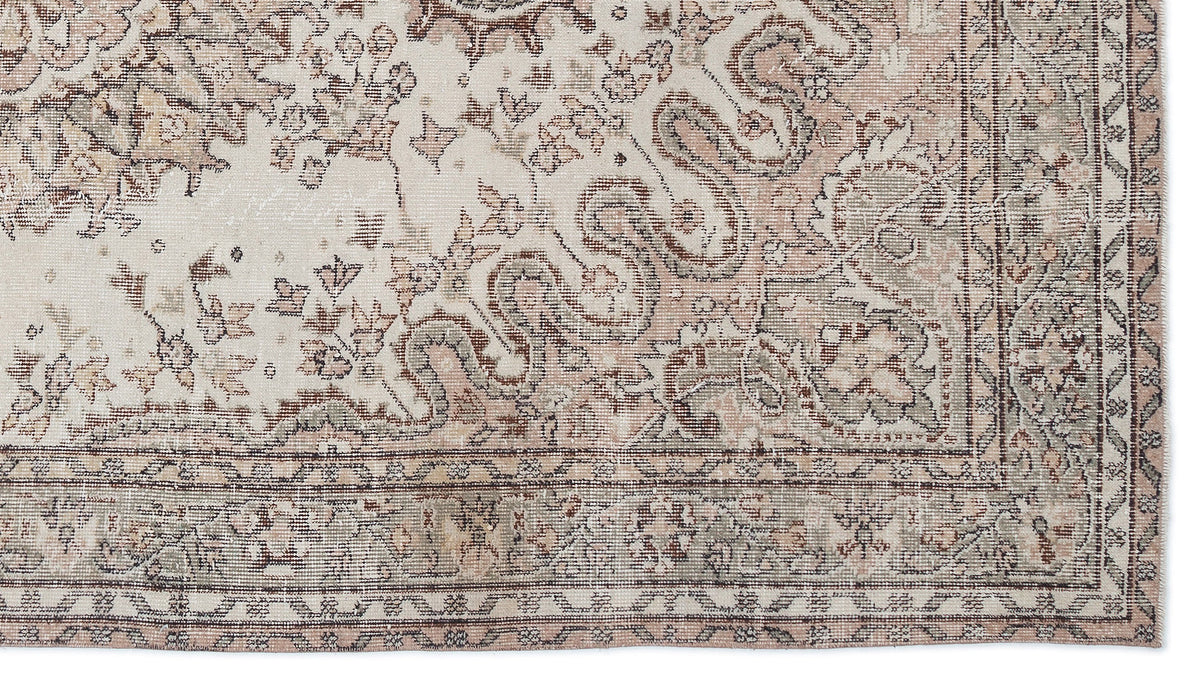Distressed cream, taupe, and sage green rug with a traditional floral medallion pattern and a decorative border.