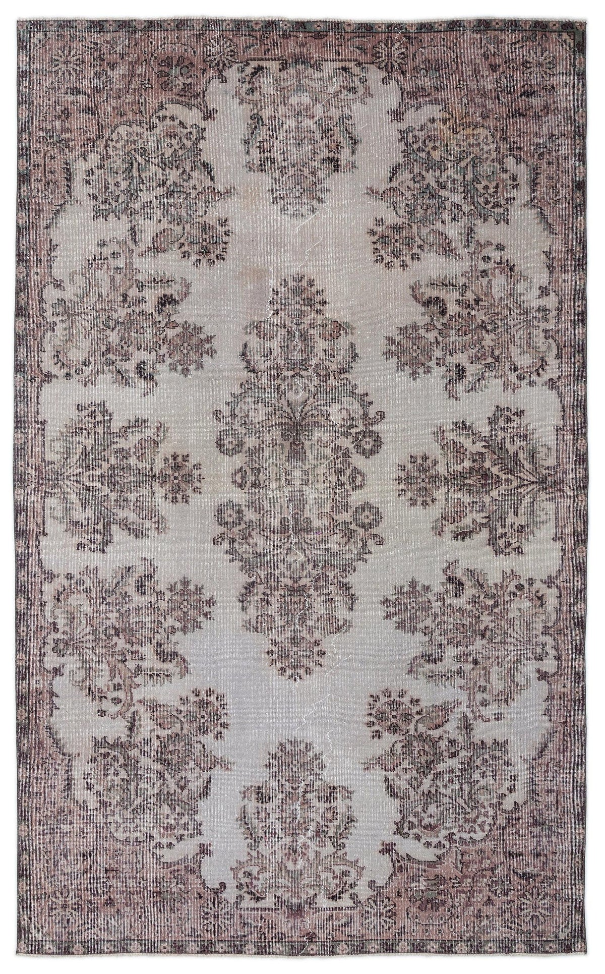 Light gray rug with a distressed, faded floral medallion pattern in muted mauve and charcoal tones.