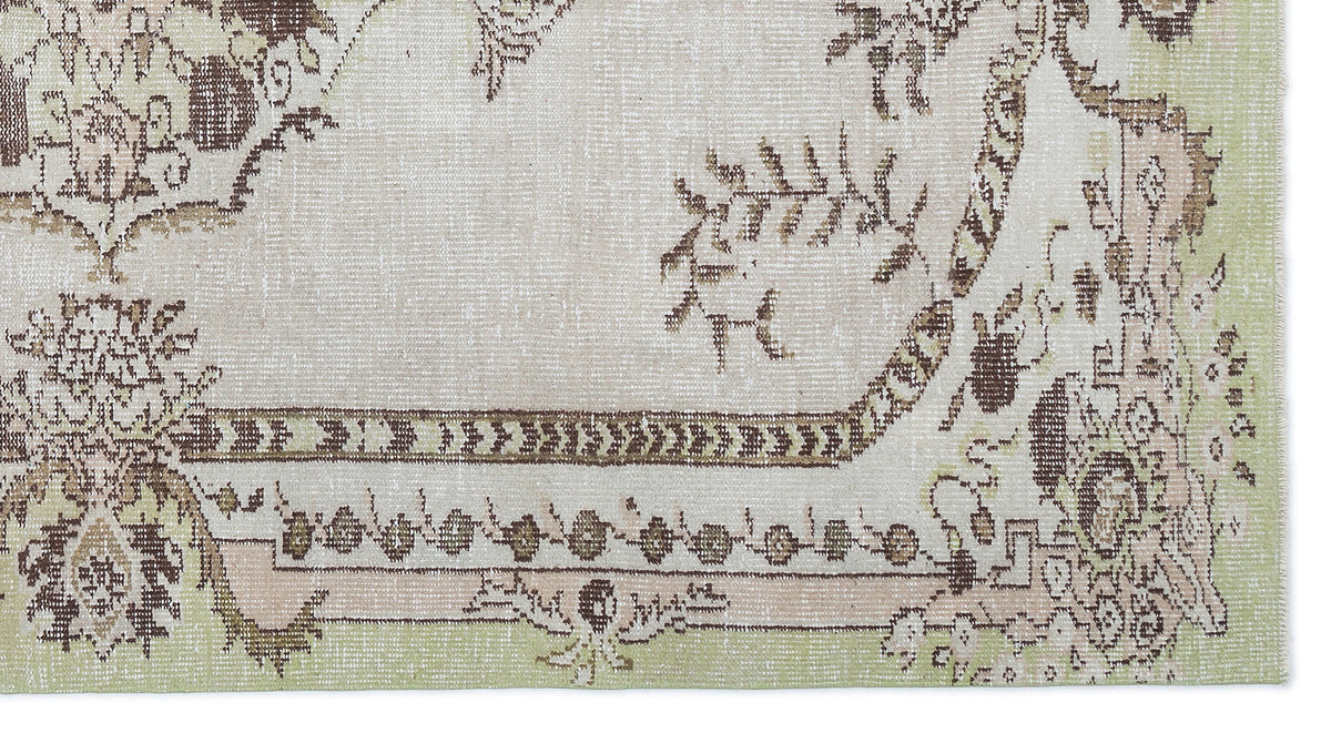Distressed beige rug with brown and sage green floral medallion patterns and a geometric border.