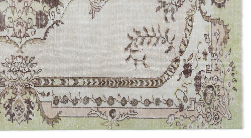 Load image 1 in gallery view. Distressed beige rug with brown and sage green floral medallion patterns and a geometric border.
