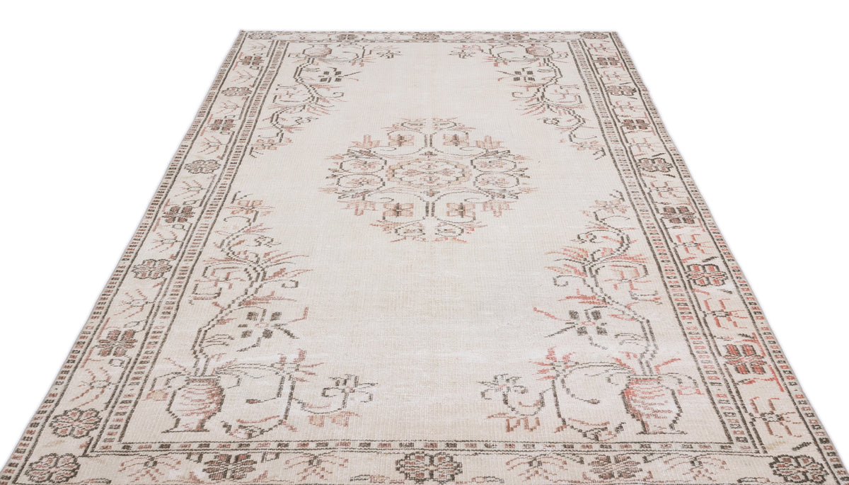 Cream area rug with a central medallion and floral border in muted brown and terracotta tones.