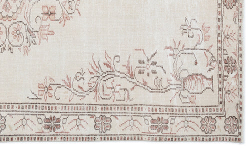 Load image 1 in gallery view. Beige rug with a faded floral medallion pattern in muted brown and terracotta, featuring a detailed geometric border.