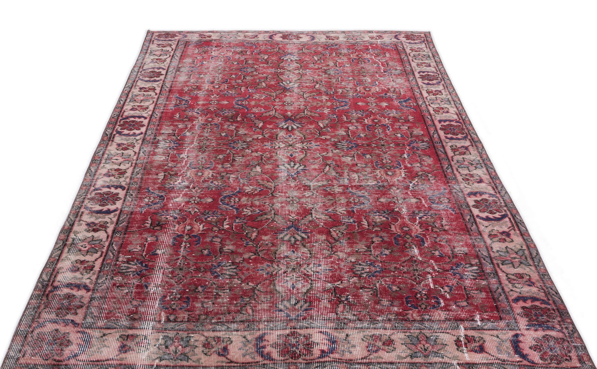 Distressed red traditional rug with a faded floral medallion pattern and a wide, ornate border on a white background.