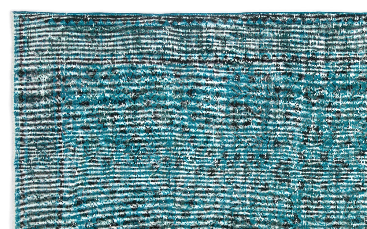 Teal and black distressed vintage-style rug with a traditional floral medallion pattern and a geometric border.