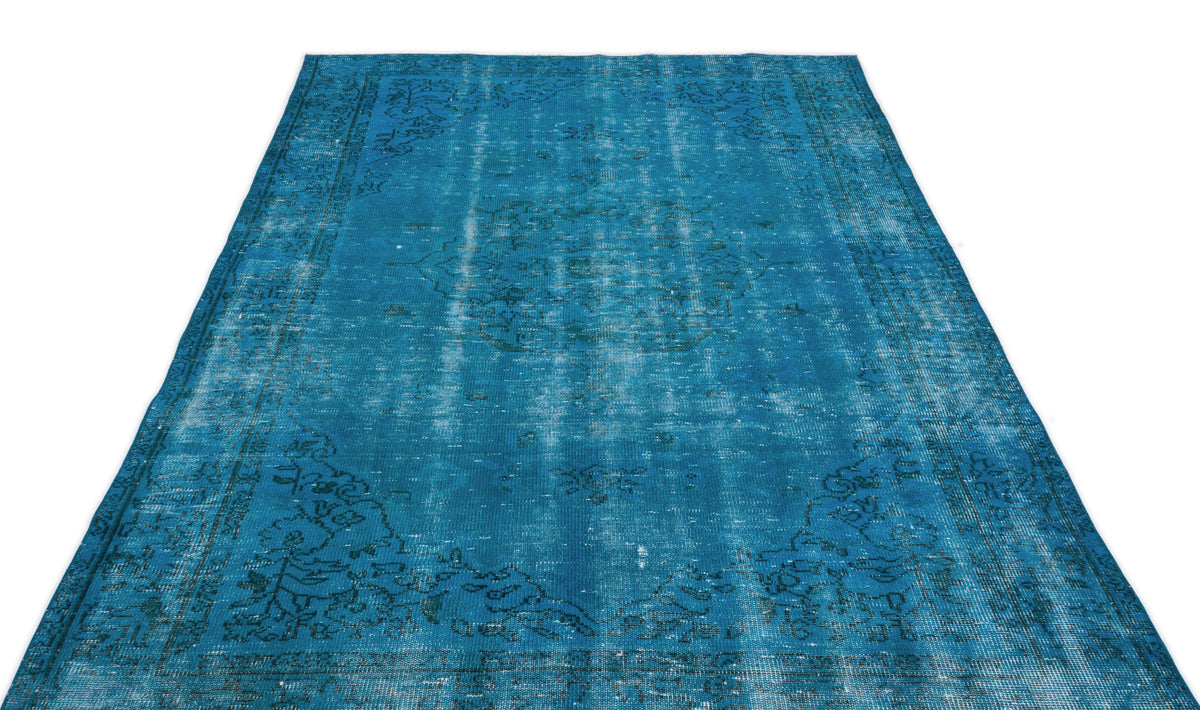 Bright blue distressed area rug with a faded traditional medallion pattern and dark border on a white background.