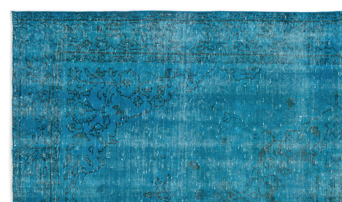 Teal distressed rug with a faded black traditional floral medallion pattern.