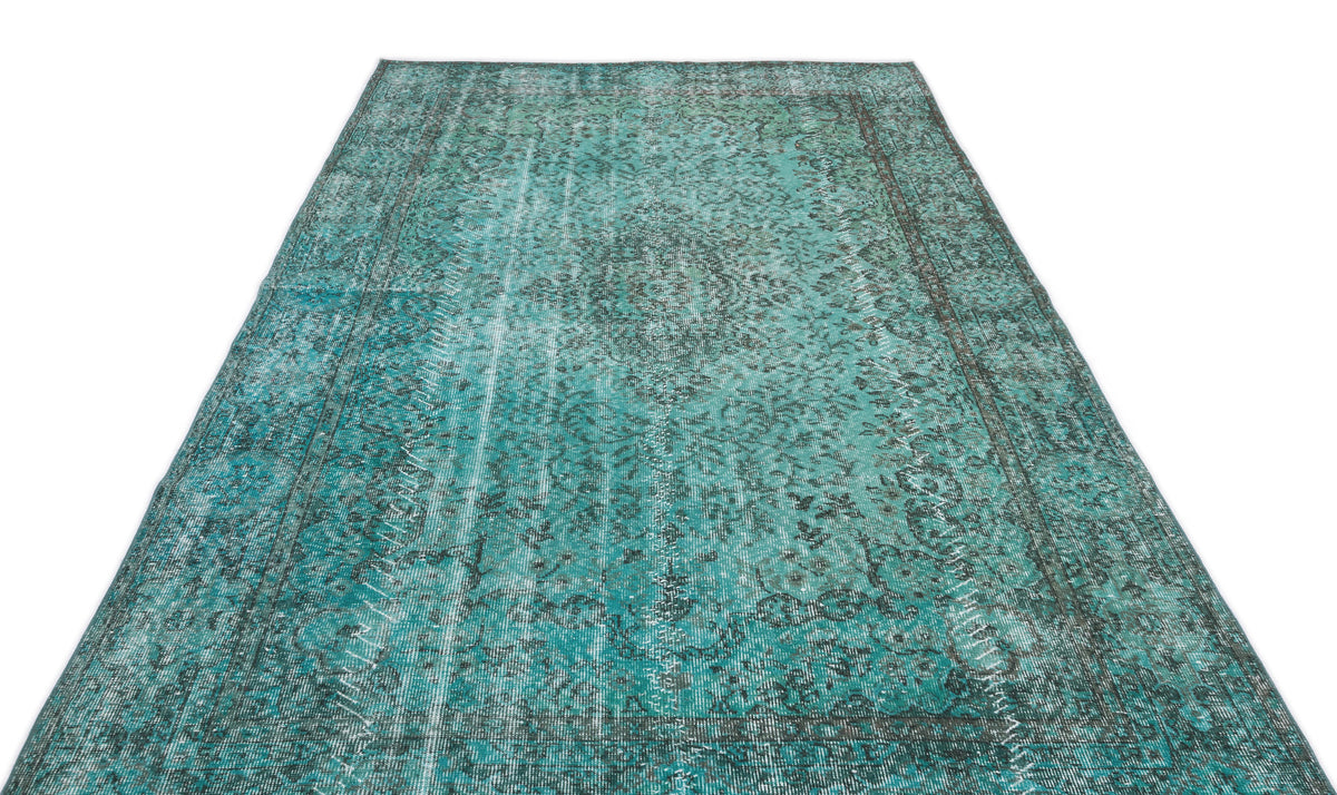 Teal and charcoal distressed vintage-style rug with an ornate central medallion and intricate floral border.