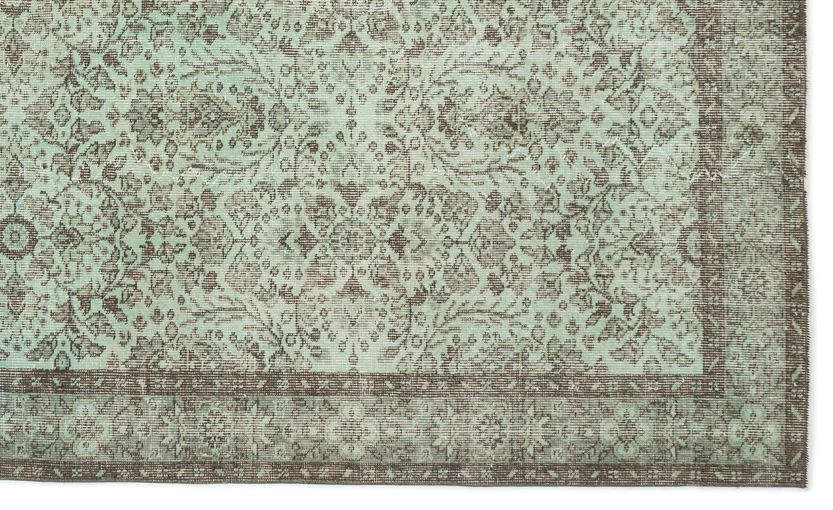 Mint green and brown rug with a distressed traditional floral medallion pattern and a wide decorative border.