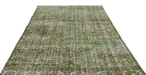Load image 1 in gallery view. Green and beige distressed rug with a repeating geometric floral medallion pattern on a white background.