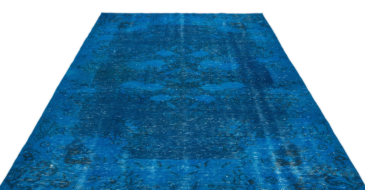 Vibrant blue distressed rug with a faded traditional medallion pattern on a white background.