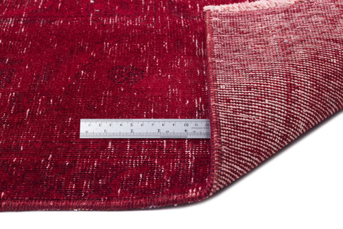 Load image 1 in gallery view. Deep red distressed rug with a visible woven backing and a stainless steel ruler for scale.