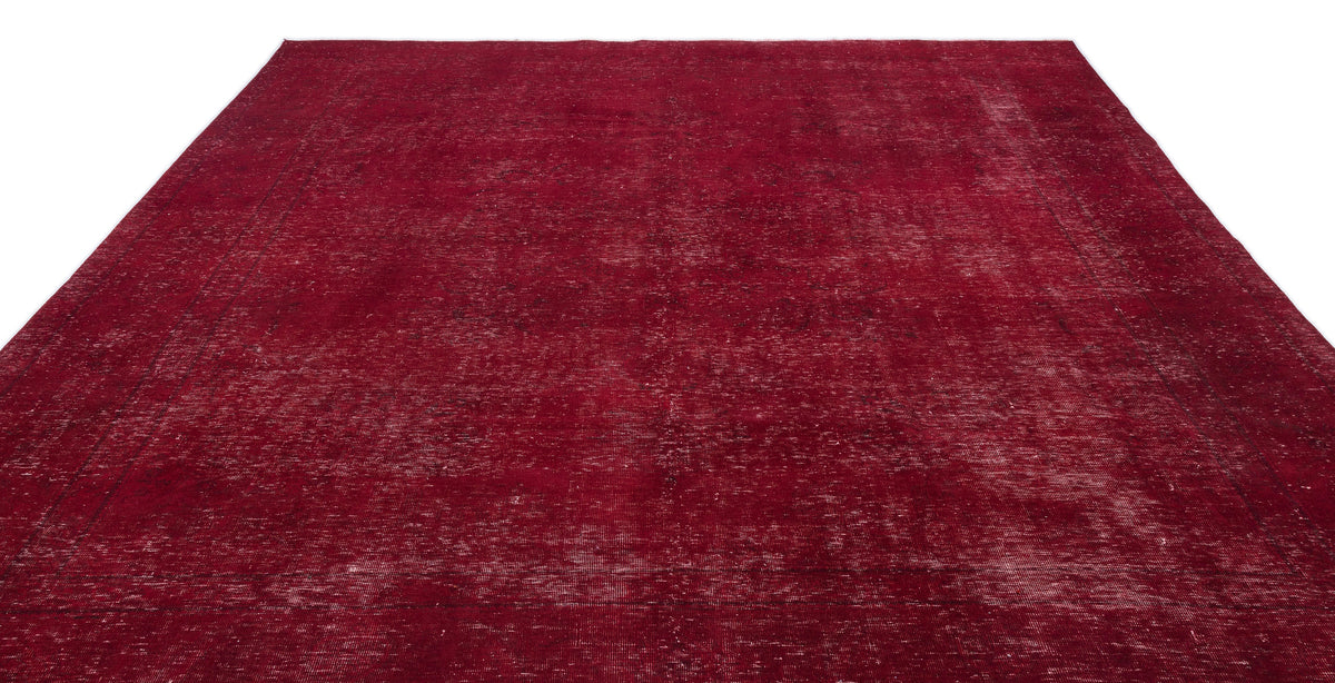 Deep red vintage-style rug with a distressed, faded texture and subtle border detail on a white background.