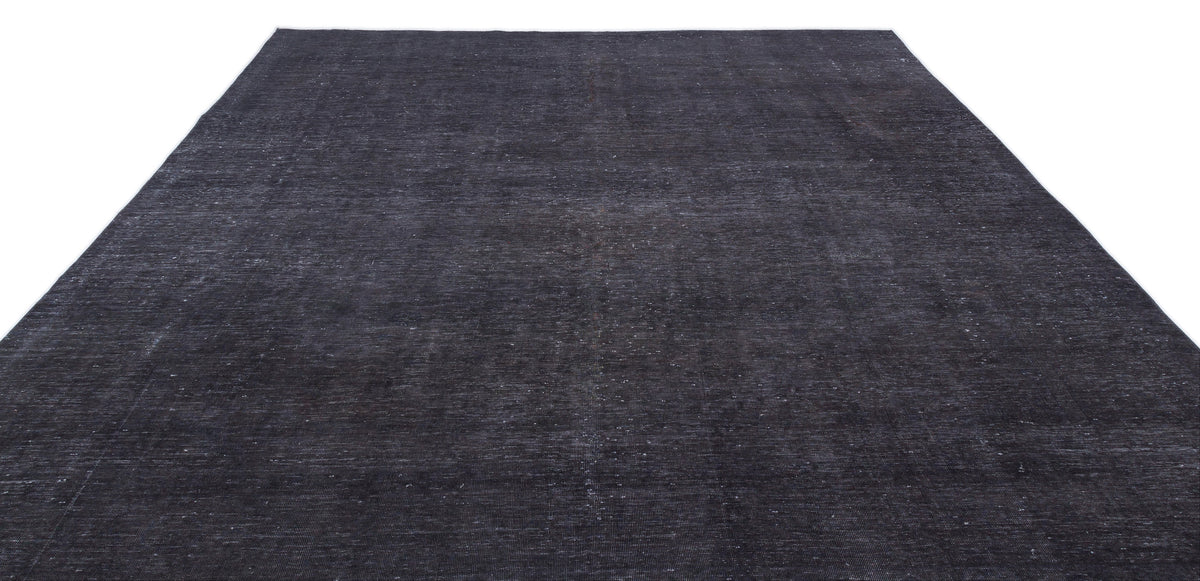 Solid charcoal black rug with a distressed, low-pile texture on a white background.