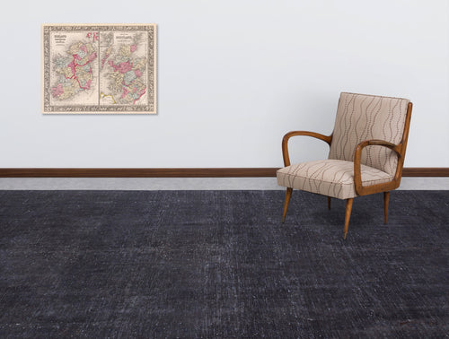 Load image 1 in gallery view. Solid charcoal grey rug with a distressed texture, styled in a room with a vintage armchair and wall map.