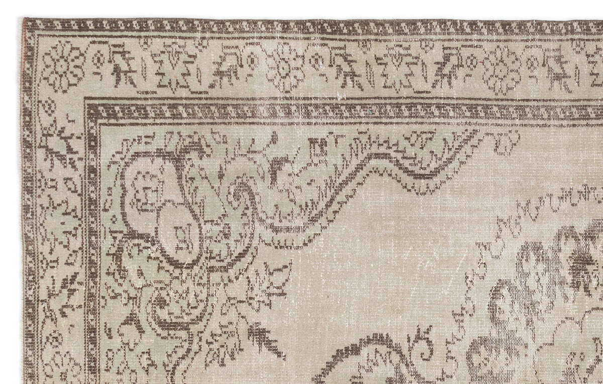 Beige and brown vintage-style rug with a distressed floral medallion pattern and a decorative border.
