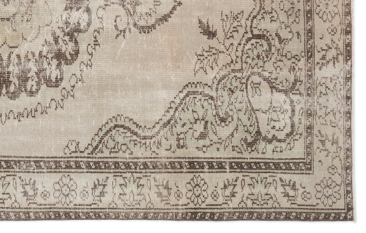 Beige and brown distressed rug with a traditional floral medallion pattern and a detailed geometric border.