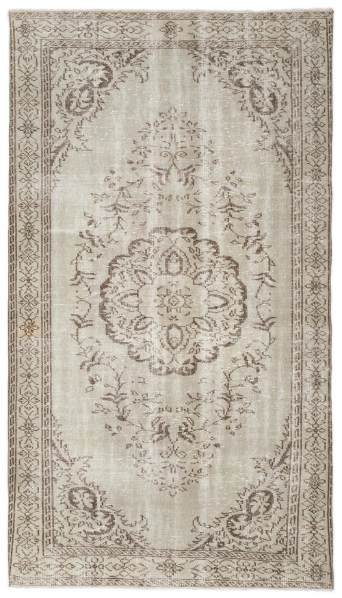 Load image 1 in gallery view. Beige and taupe distressed area rug with a central floral medallion and an ornate geometric border.