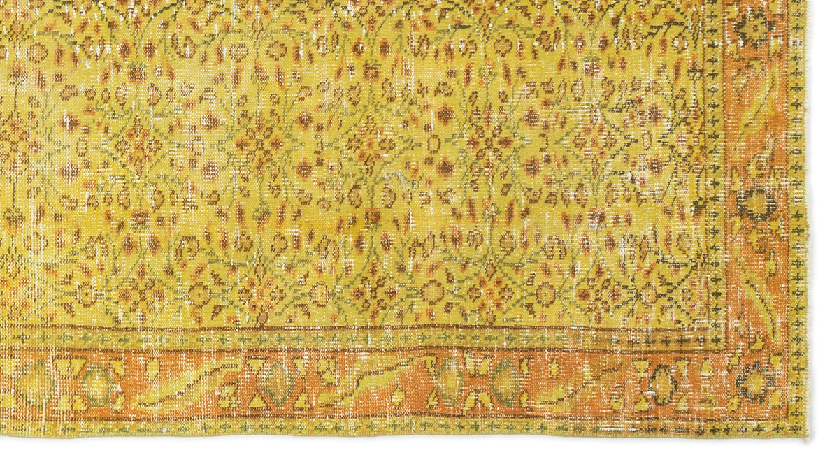 Mustard yellow and orange distressed rug with a traditional floral medallion pattern and a wide decorative border.