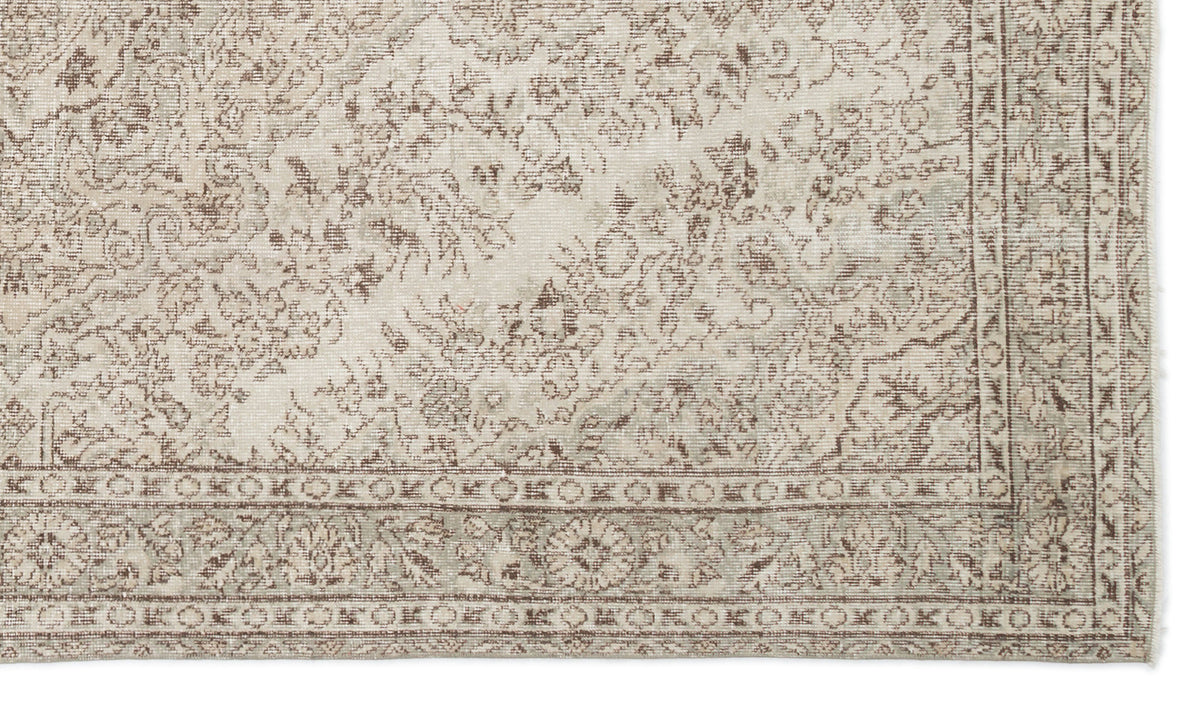 Beige and taupe traditional rug with a distressed floral medallion pattern and a detailed geometric border.