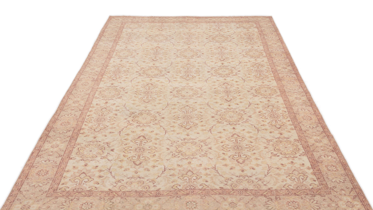 Beige and muted red traditional area rug with a repeating floral medallion pattern and a decorative border.