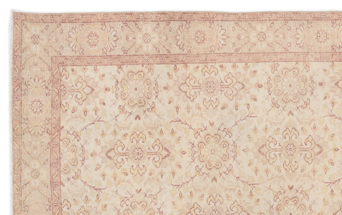 Beige and muted rose traditional rug with a faded floral medallion pattern and a detailed border.