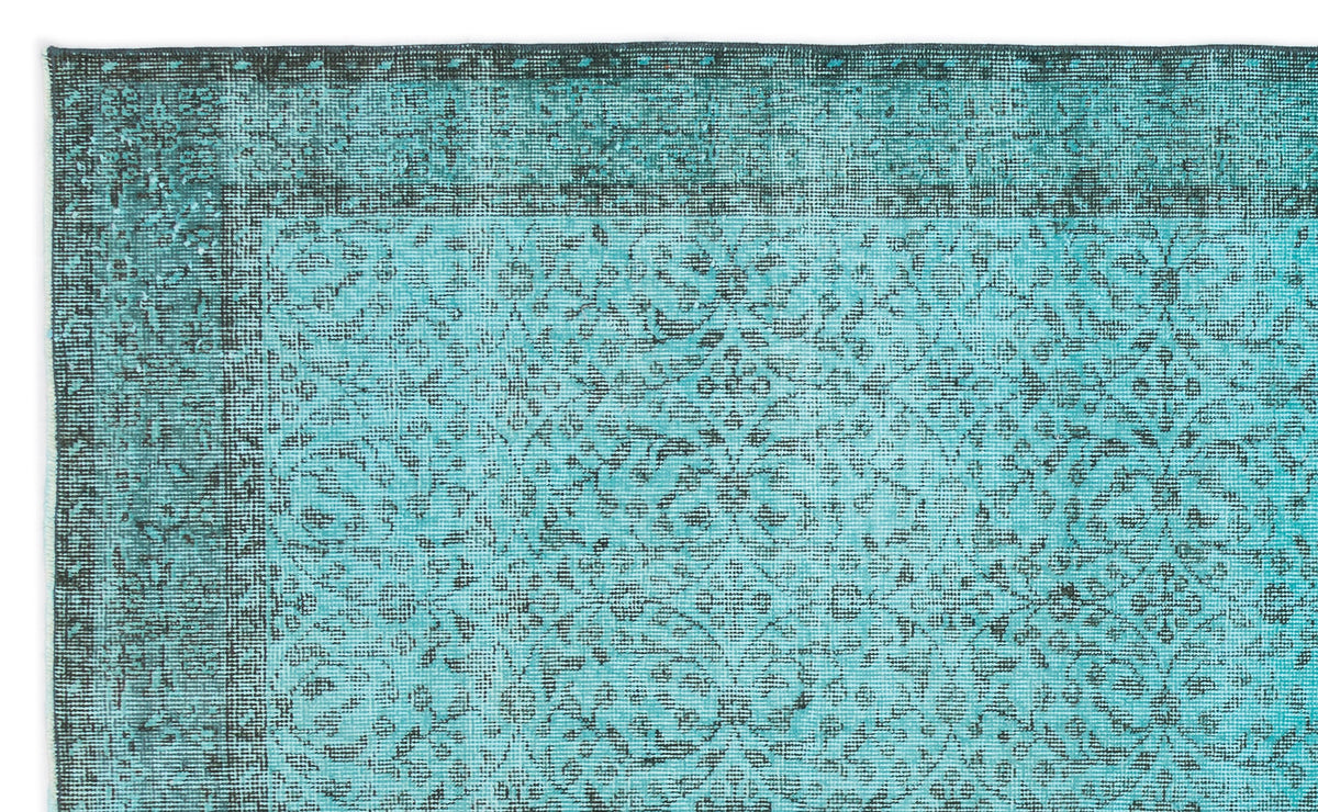 Teal and black distressed rug with a traditional floral medallion pattern and a wide decorative border.