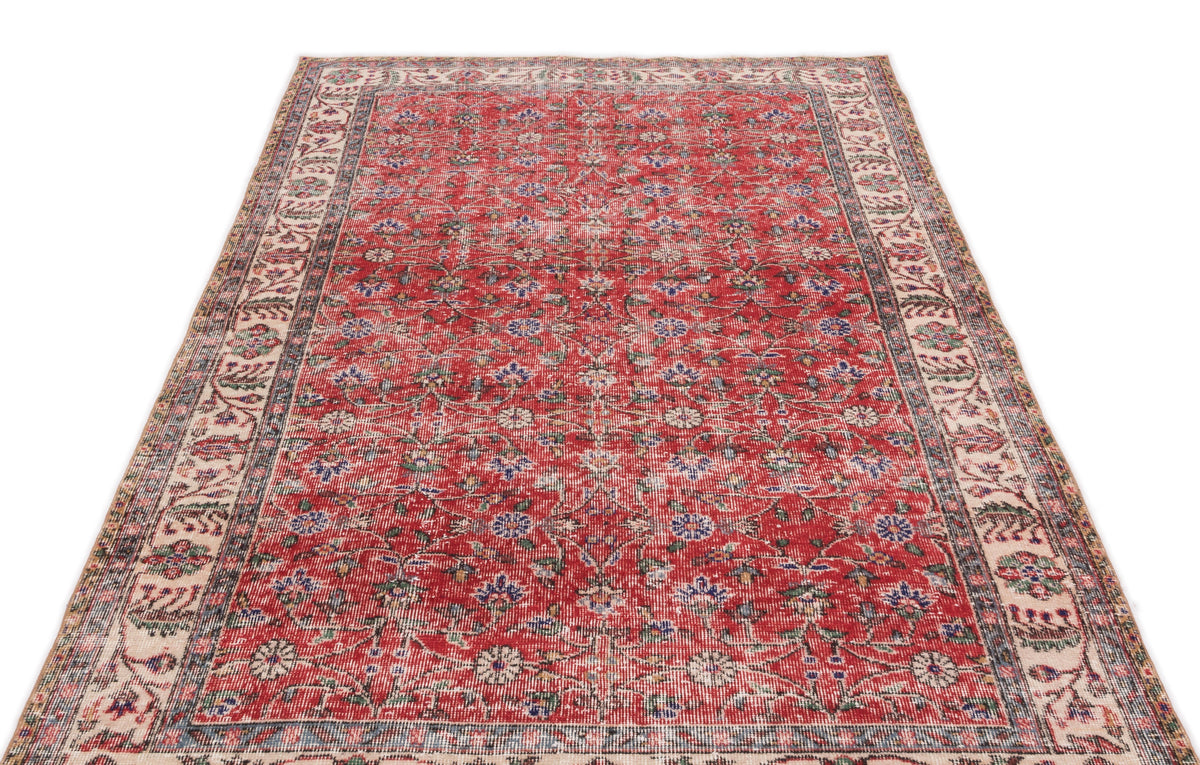 Red vintage-style rug with a distressed floral pattern and a cream border, isolated on a white background.
