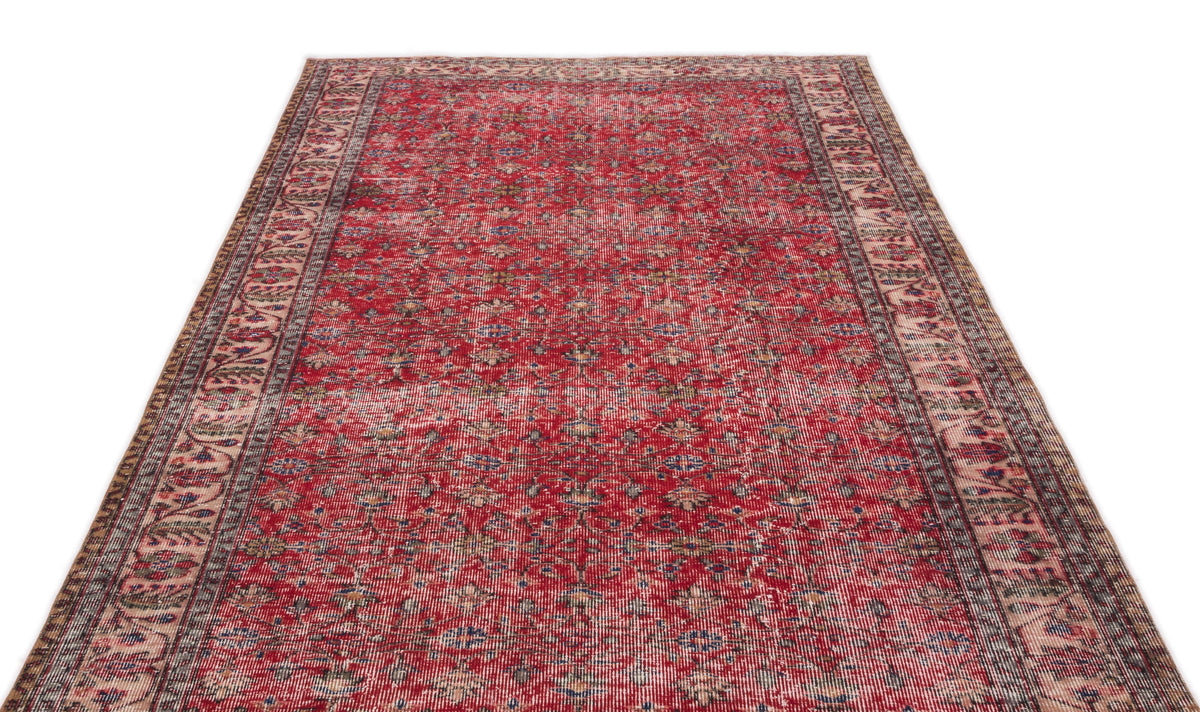 Red vintage-style rug with a distressed floral pattern and intricate border on a white background.