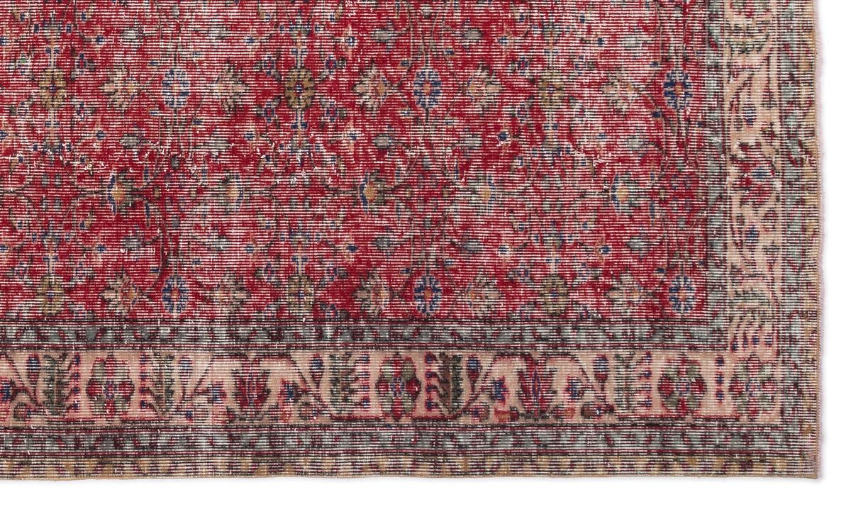 Red traditional rug with a distressed floral pattern and a detailed cream and blue border.