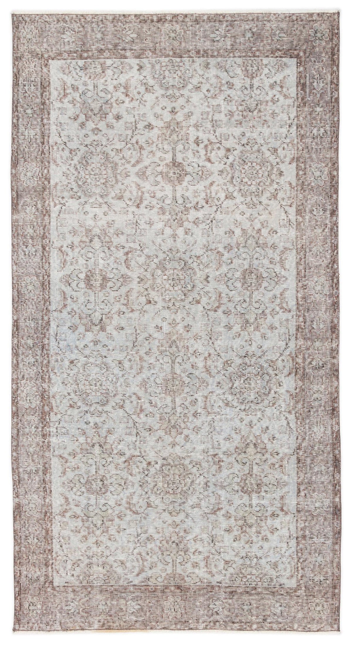 Distressed taupe and light grey rug with a traditional floral medallion pattern and a wide decorative border.