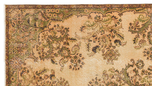 Load image 1 in gallery view. Distressed beige rug with a dark green and brown floral pattern and a decorative border.