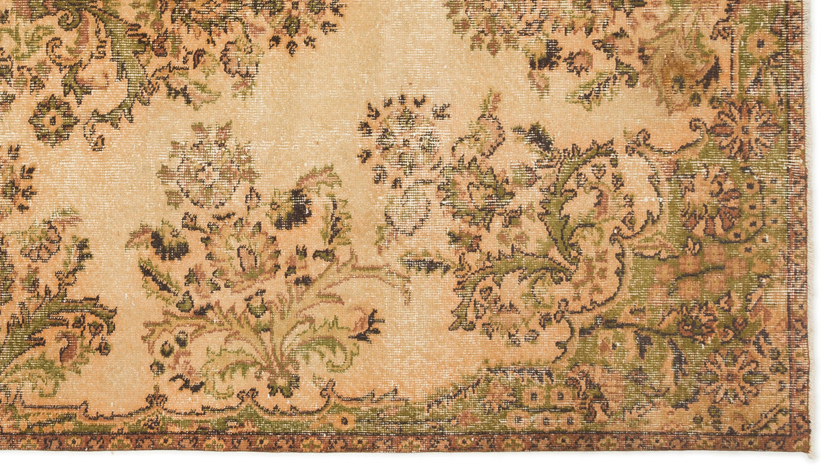 Distressed beige rug with a faded green and brown floral medallion pattern.