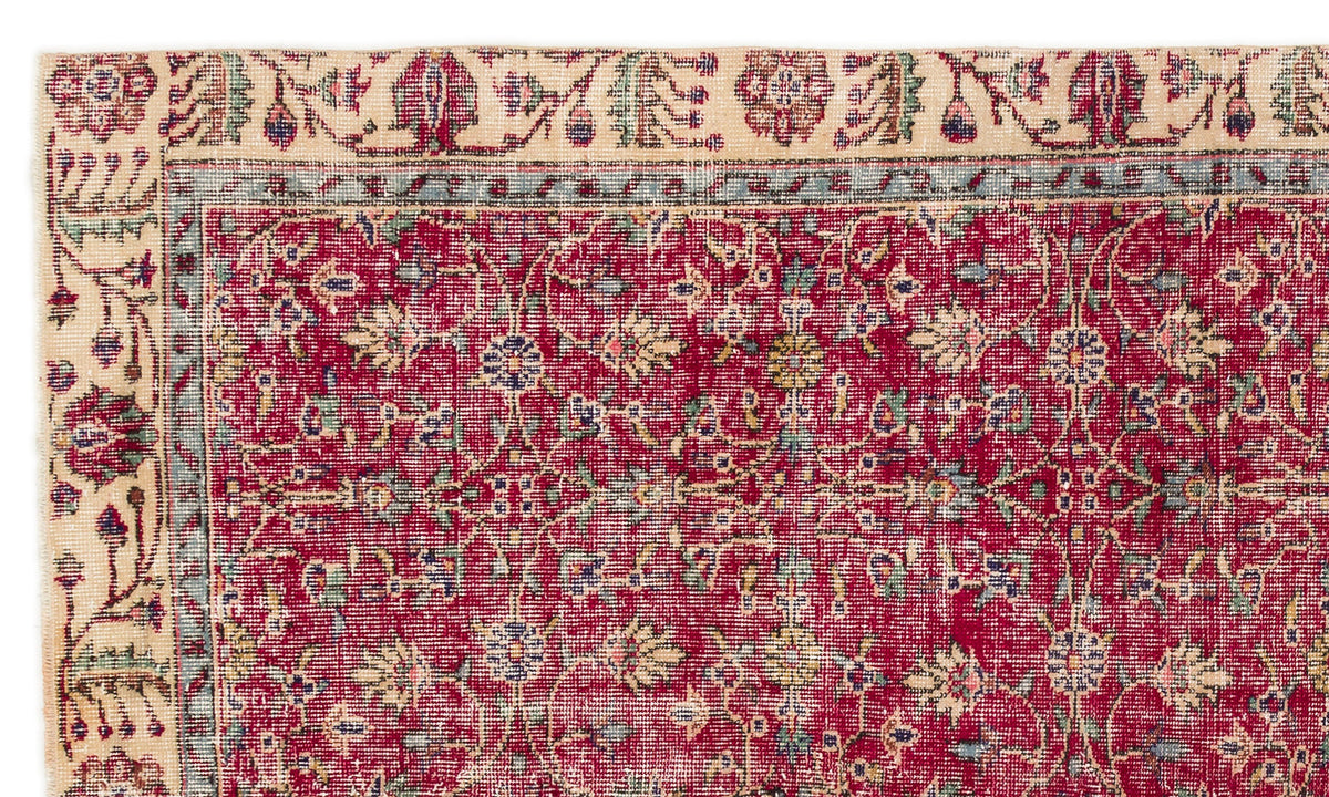 Red traditional rug with a floral vine pattern, a blue border, and a cream-colored outer edge.
