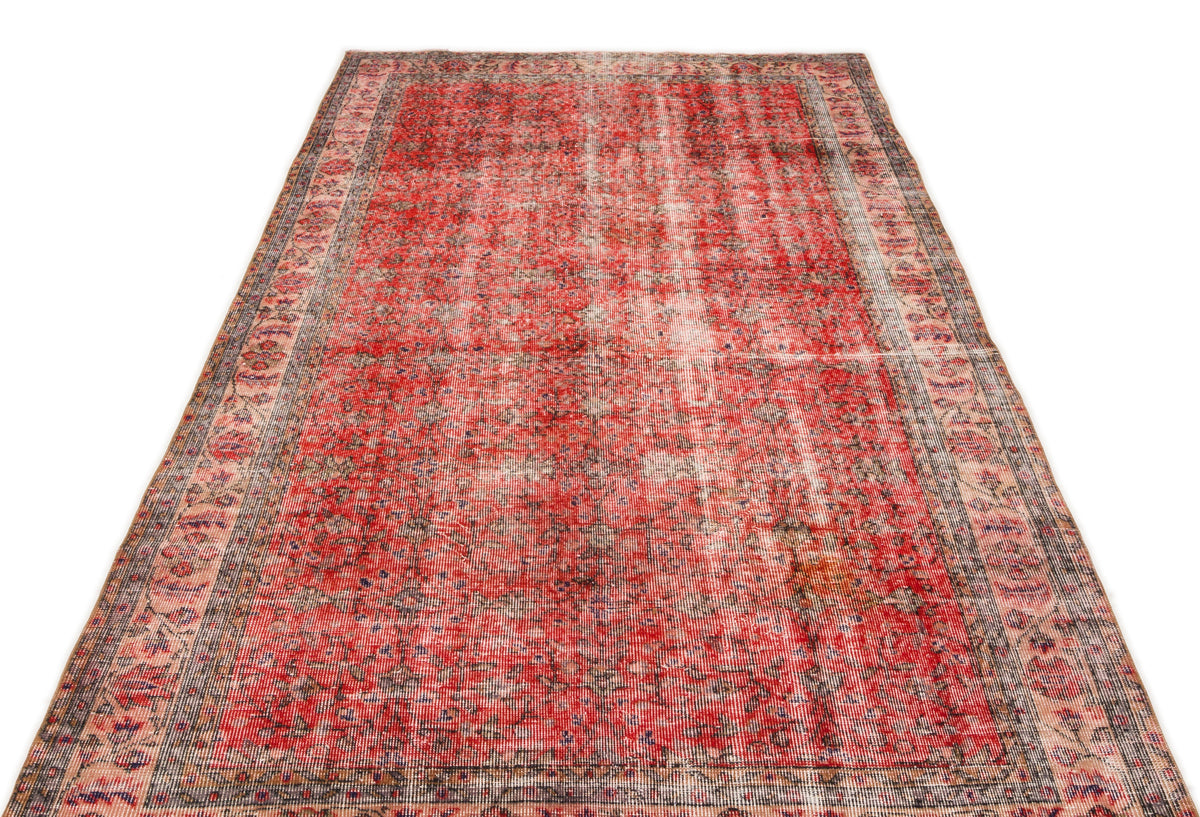 Distressed red and cream vintage-style rug with a faded traditional medallion pattern and a detailed border.