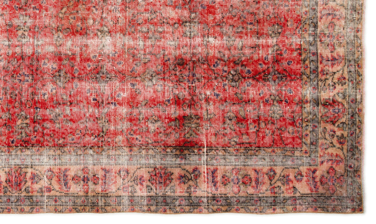 Distressed red and beige rug with a faded floral border and traditional medallion pattern on a white background.