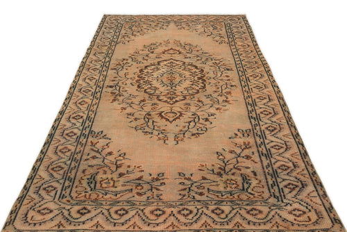 Load image 1 in gallery view. Distressed peach and brown vintage-style rug with a central floral medallion and geometric border on a white background.