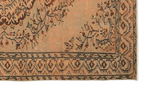 Load image 1 in gallery view. Distressed peach and brown rug with a traditional floral medallion pattern and a geometric border.