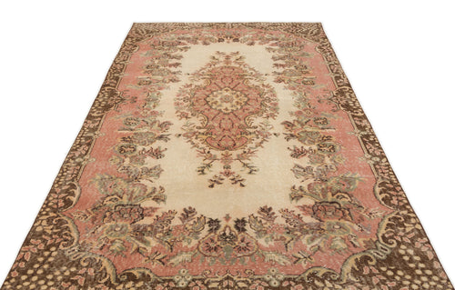 Load image 1 in gallery view. Cream, pink, and brown vintage-style rug with a central floral medallion and ornate border on a white background.