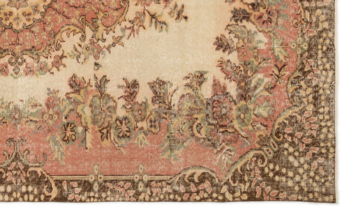 Load image 1 in gallery view. Distressed vintage-style rug with a cream center, floral motifs in muted pink and green, and a dark brown border.