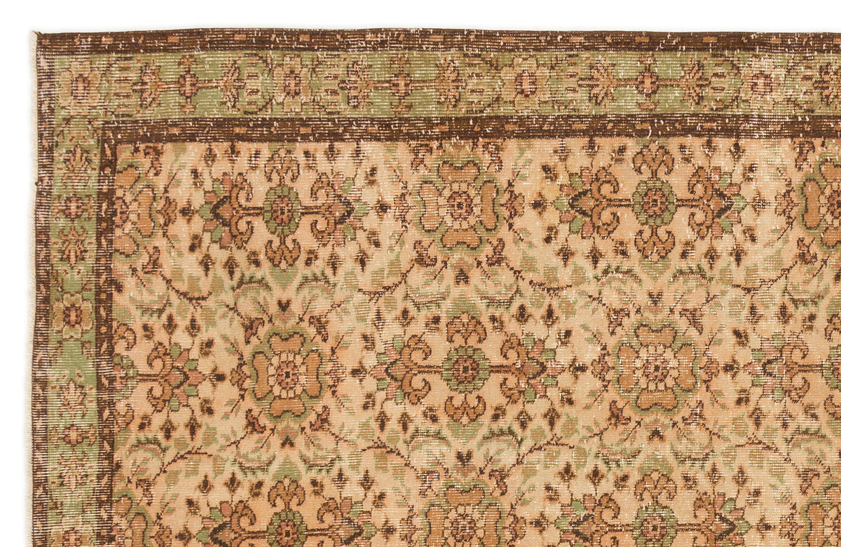 Beige, sage green, and brown vintage-style rug with a repeating floral medallion pattern and a decorative border.