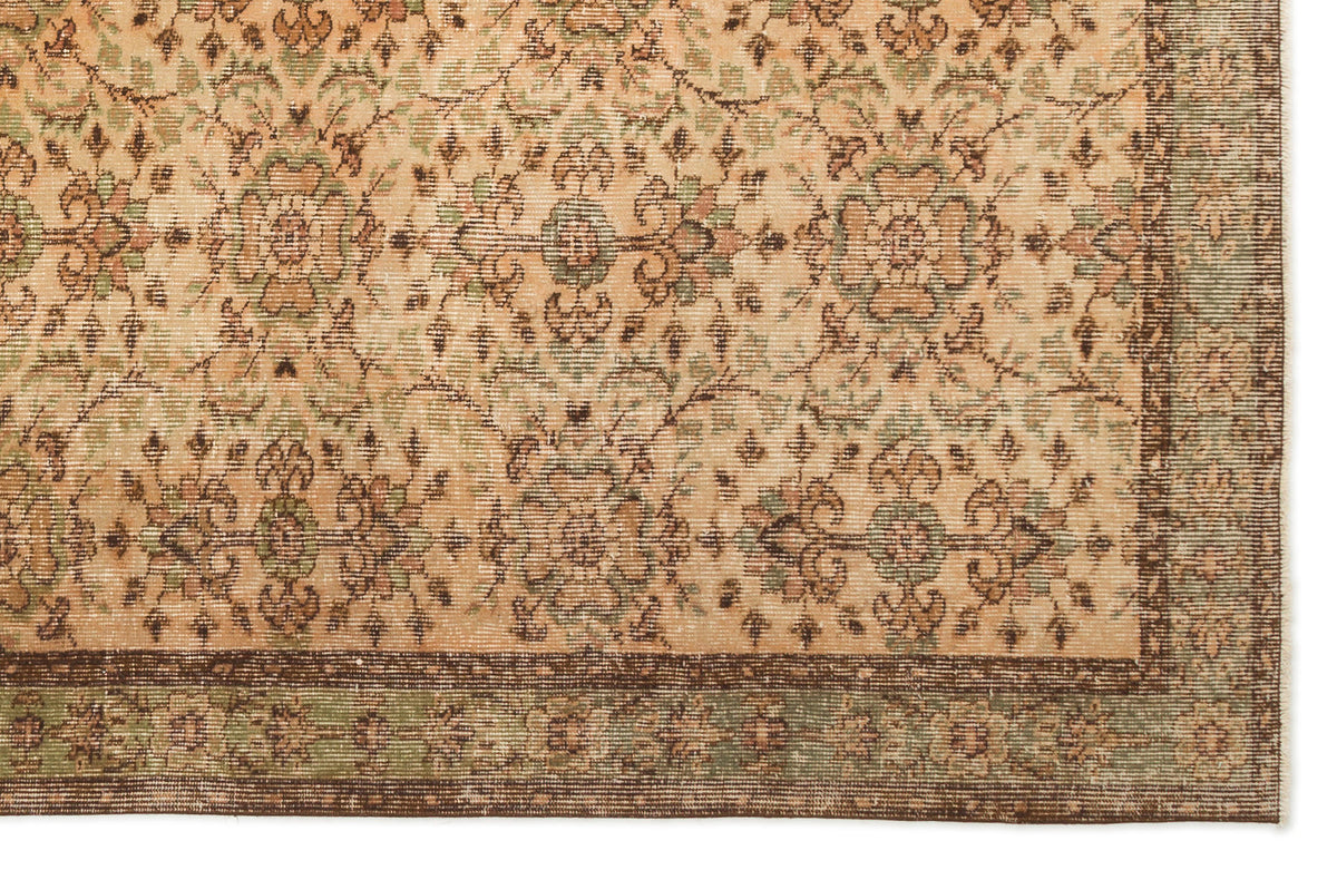 Beige rug with a repeating floral medallion pattern in sage green and brown, featuring a dark brown border.
