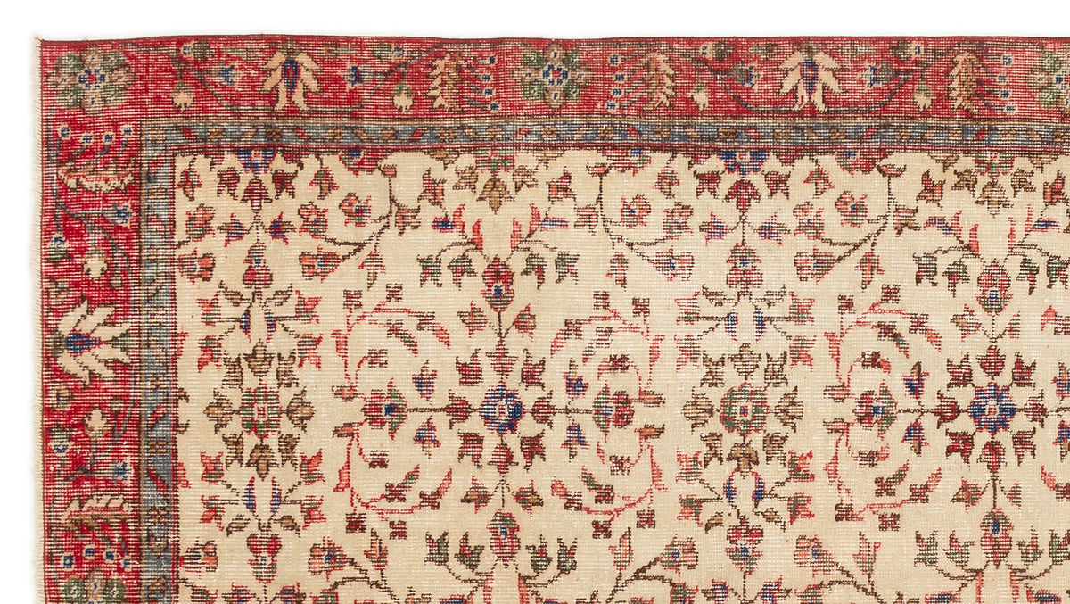 Cream rug with a red border and intricate floral medallion pattern in red, blue, and green.