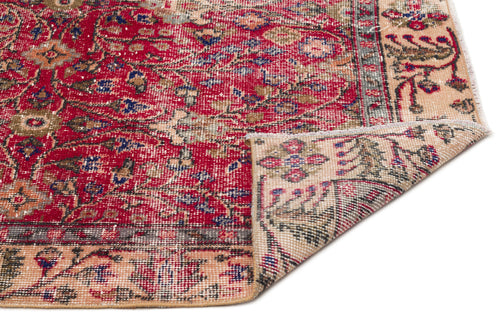 Load image 1 in gallery view. Red and beige traditional rug with a distressed floral medallion pattern and a folded corner, on a white background.