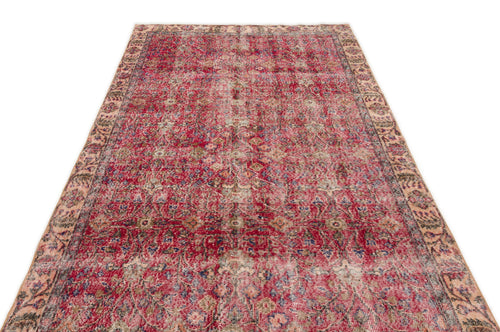 Load image 1 in gallery view. Distressed red vintage-style rug with a faded floral medallion pattern and a beige decorative border.