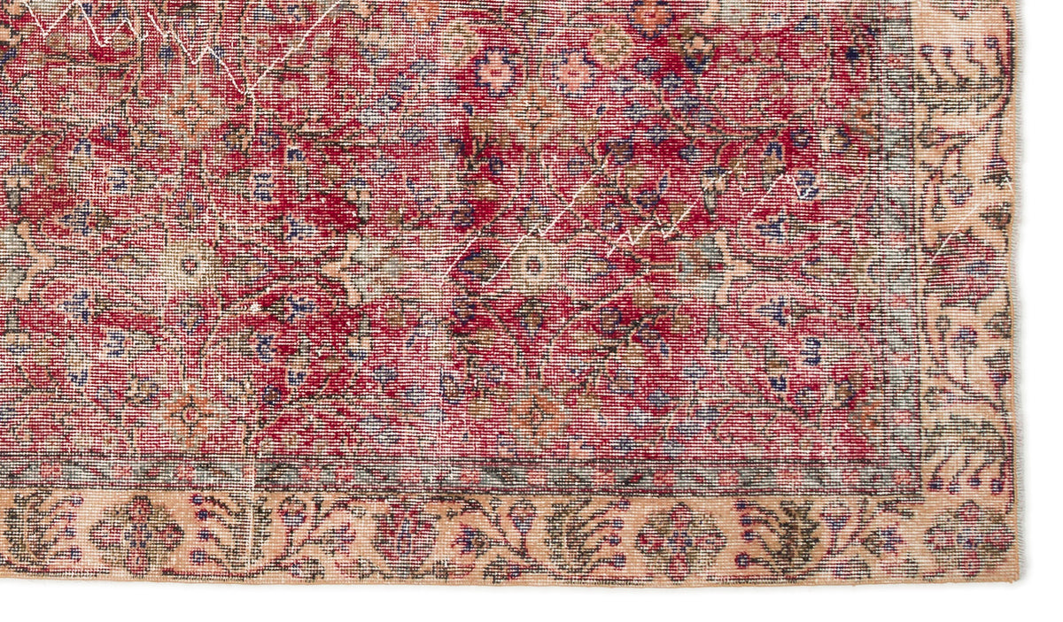 Distressed red and beige vintage-style rug with a traditional floral medallion pattern and a wide decorative border.