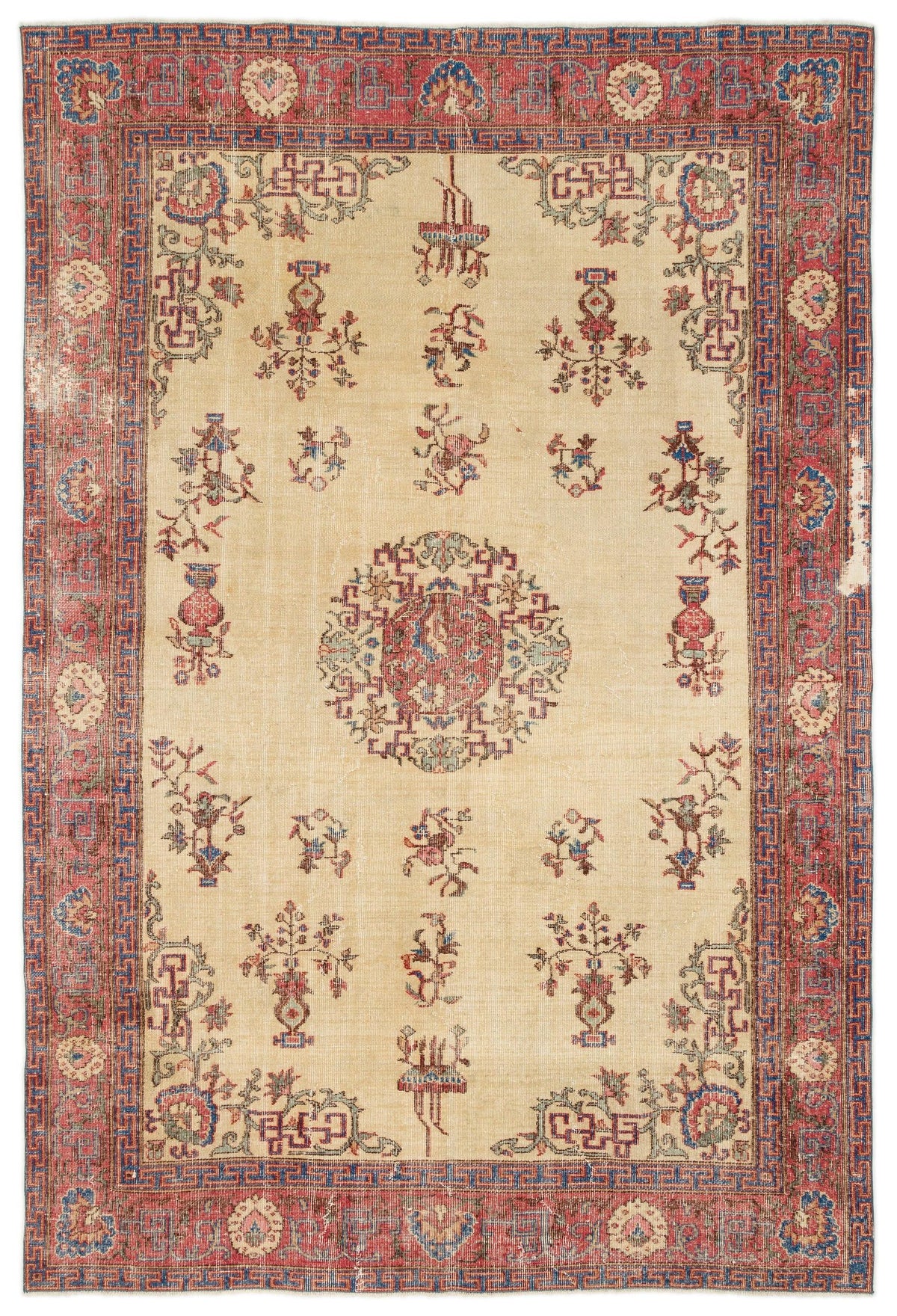 Beige vintage rug with a central medallion, scattered floral motifs, and a red and blue geometric border.