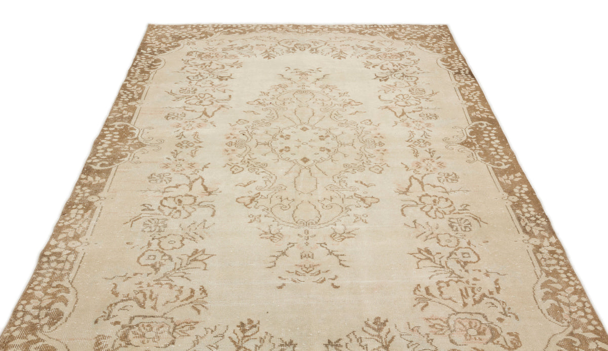 Beige and tan vintage-style rug with a central floral medallion and ornate border on a white background.
